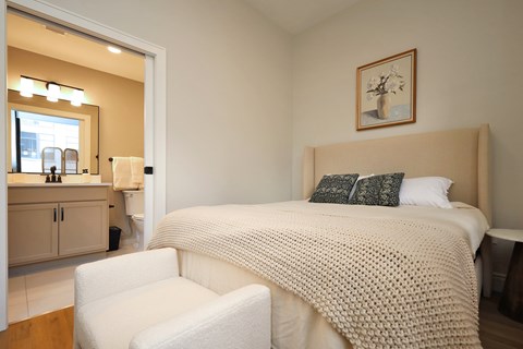 Bedroom with ensuite bath and upholstered headboard at The Electric Building Apartments, Cleveland, OH