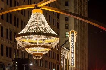 A large chandelier hangs from a ceiling in front of a sign that says "LAYHOUSE SQUARE.".