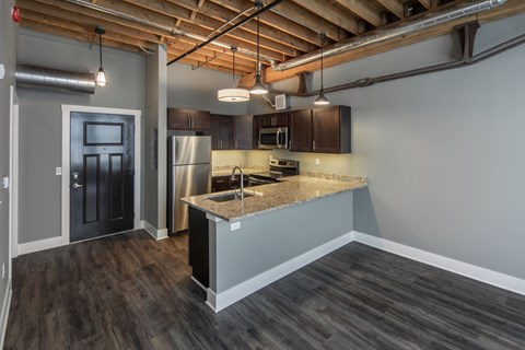 a kitchen with a granite counter top and a stainless steel refrigerator