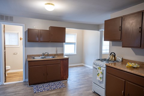 A kitchen with a white stove and brown cabinets.