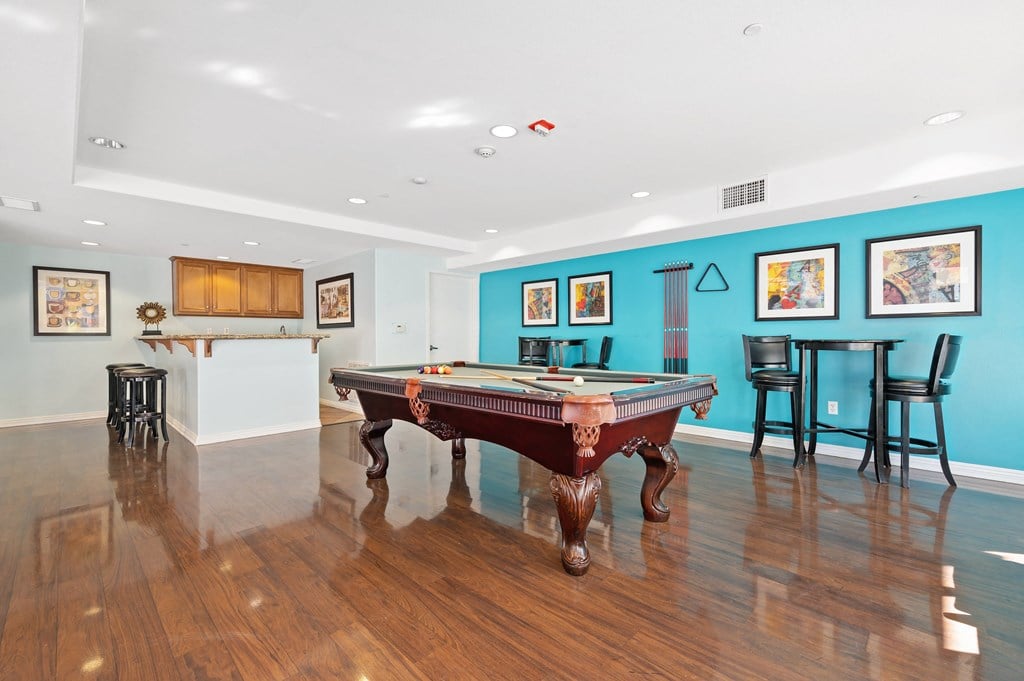 a game room with a pool table and bar