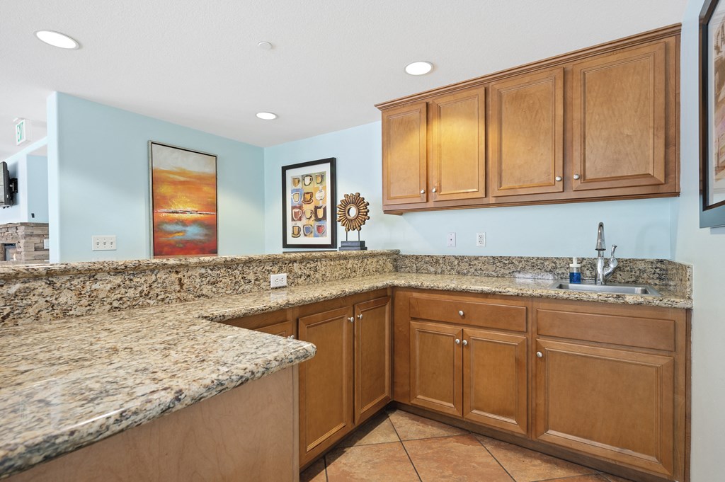 a kitchen with granite countertops and wooden cabinets