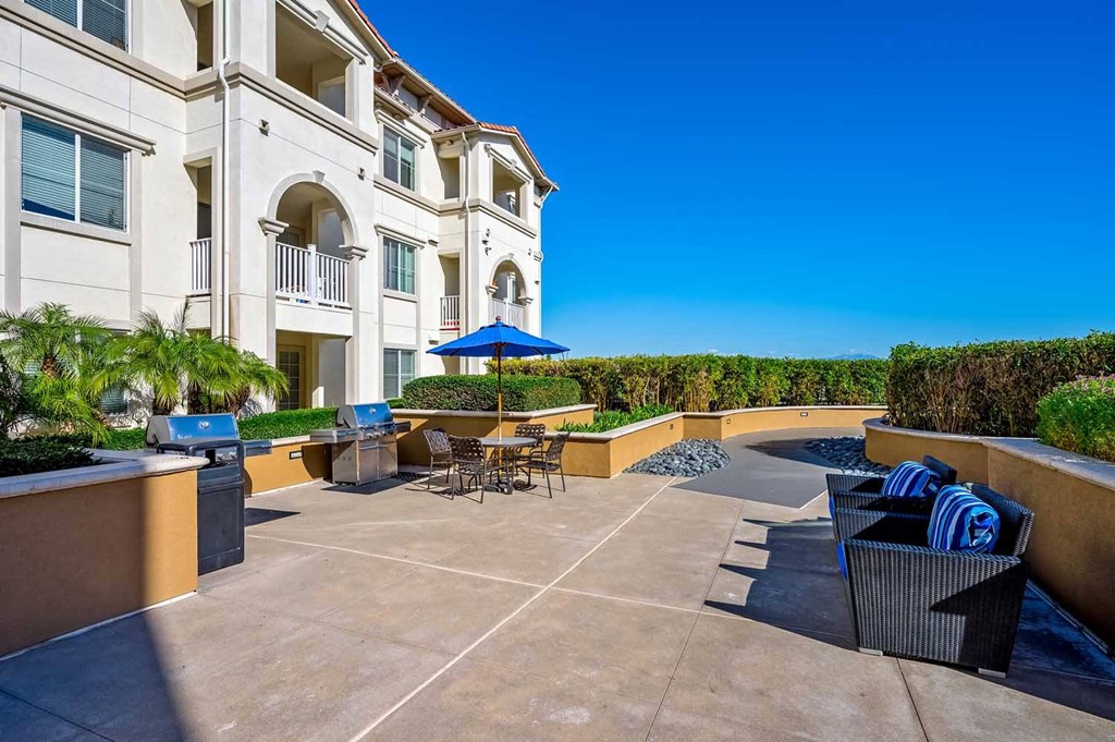 a patio with tables and chairs in front of a building