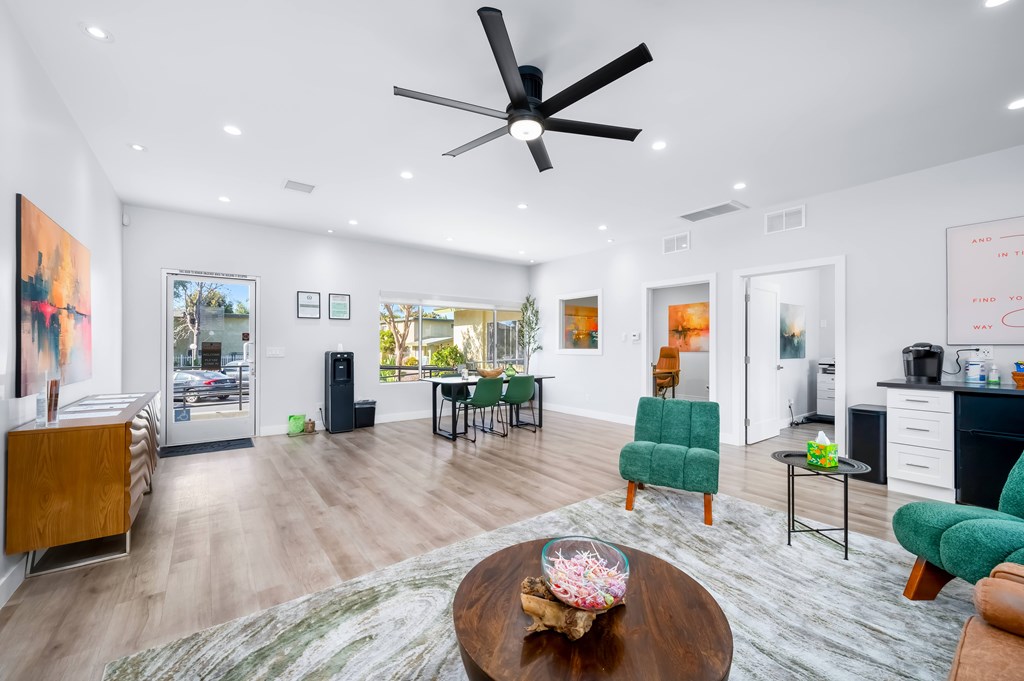 A modern living room with a wooden coffee table and green chairs.