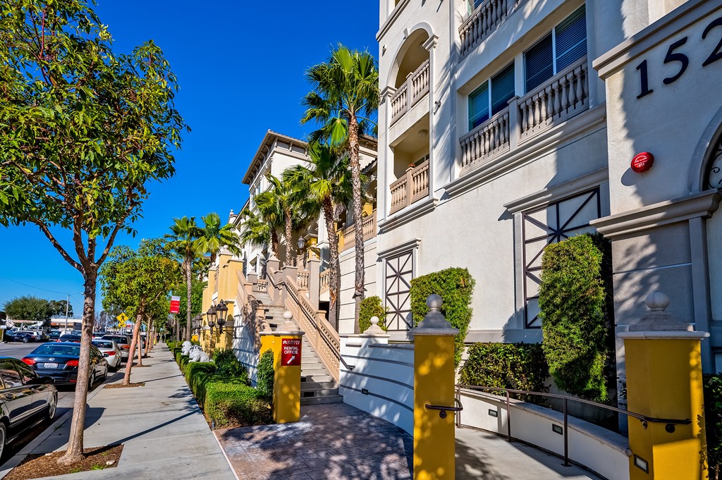 a row of apartment buildings with palm trees in the background