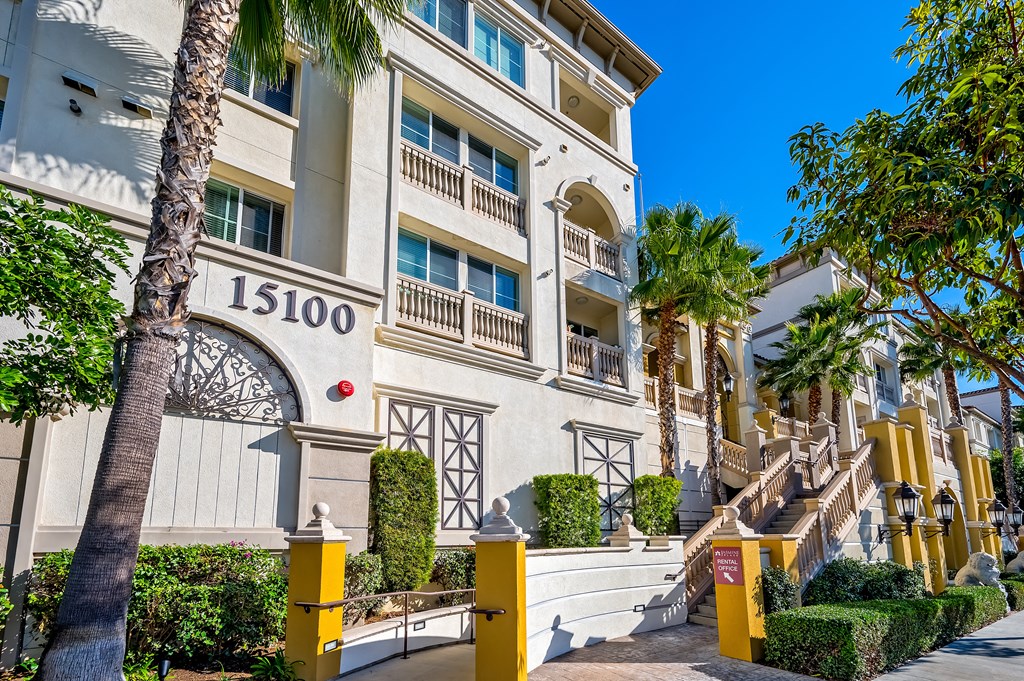 a building with a staircase and trees in front of it