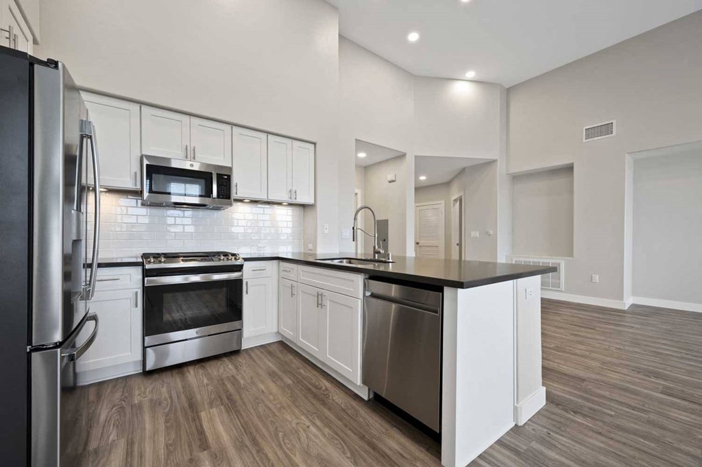 a kitchen with stainless steel appliances and white cabinets