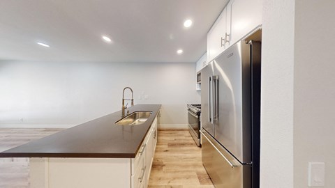 a kitchen with white cabinets and a stainless steel refrigerator