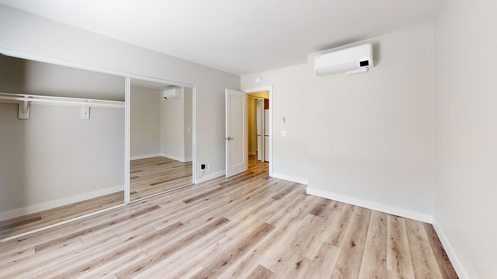 an empty room with wood floors and white walls