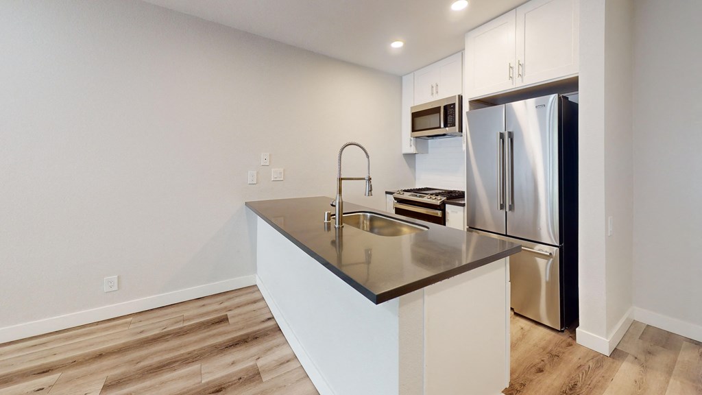 a kitchen with a large island and a stainless steel refrigerator