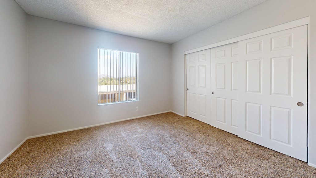 an empty room with carpet and a window