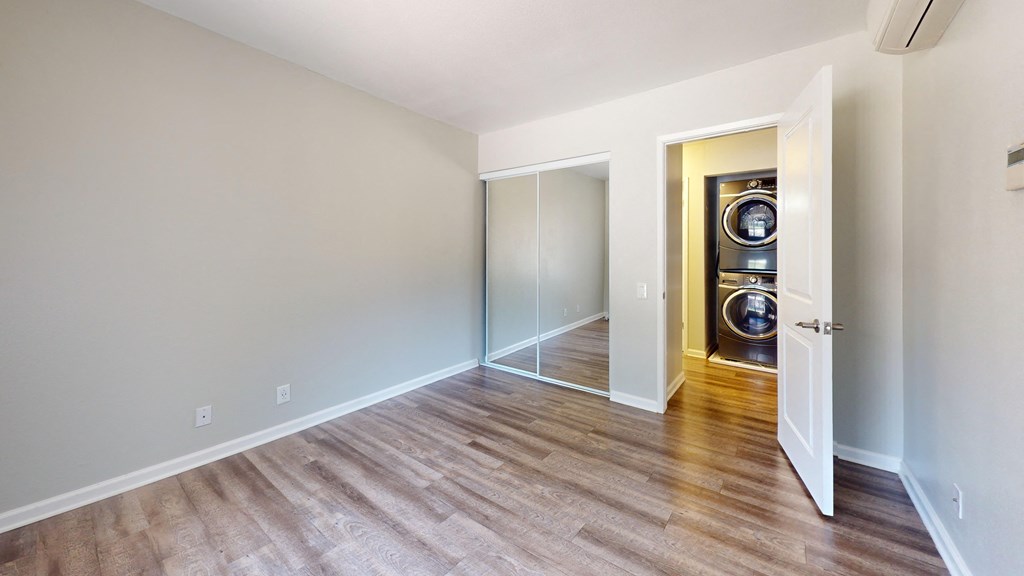 a empty room with a washer and dryer in it and a door open