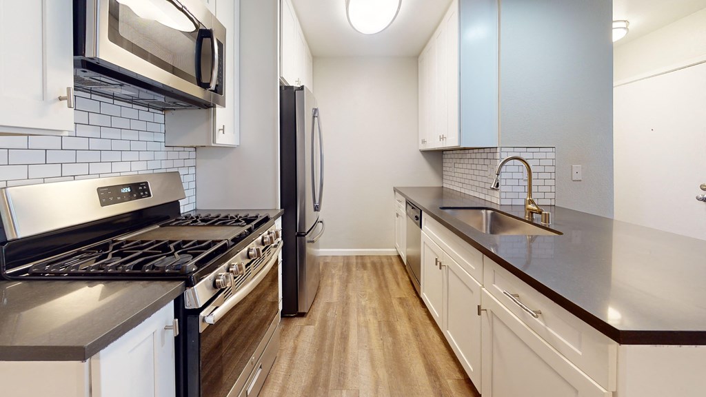 a kitchen with stainless steel appliances and white cabinets