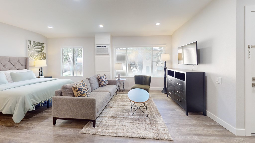 a living room with a couch and a chair and a bed