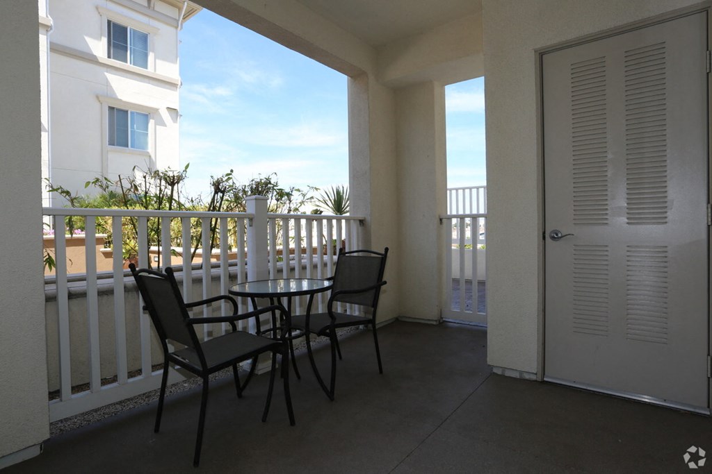 a patio with a table and chairs on a balcony