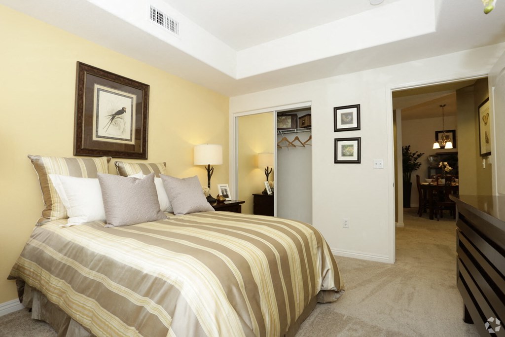 a bedroom with a bed and a hallway to a living room