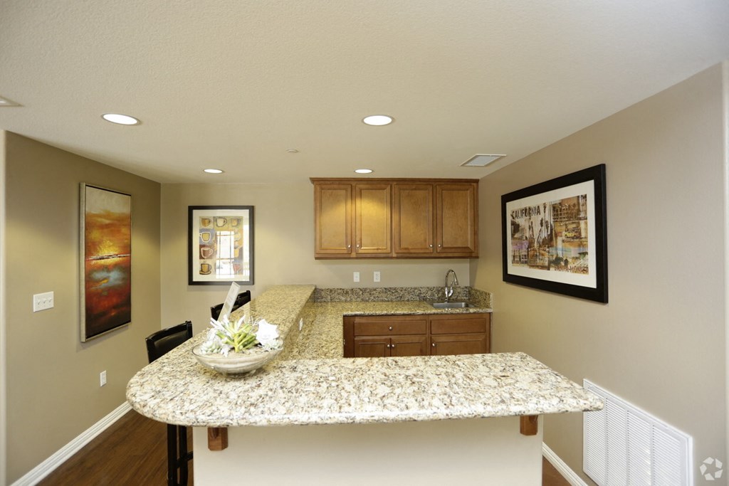 a kitchen with a granite counter top and wooden cabinets