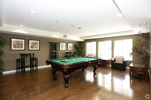 a game room with a pool table in the center