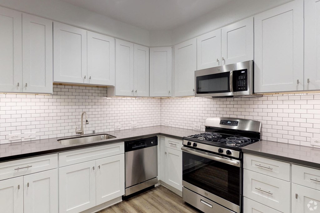 a kitchen with white cabinets and a stove and a microwave
