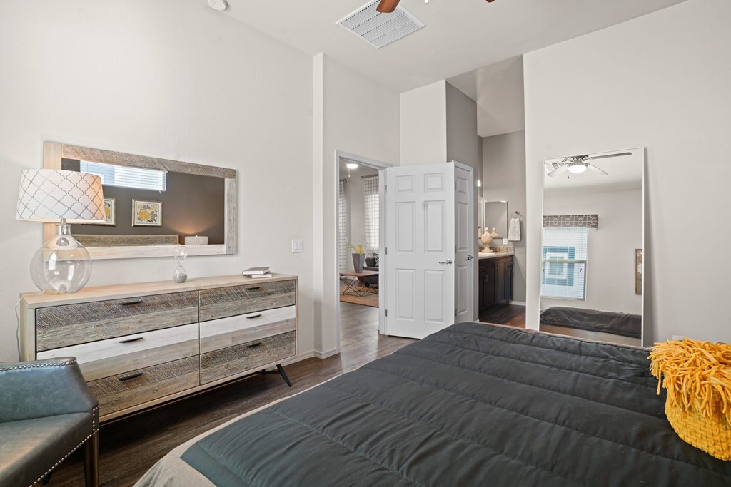A bedroom with a bed, dresser, and mirror.
