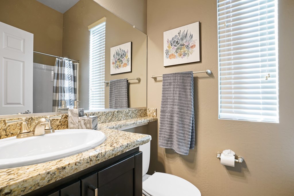 A bathroom with a toilet, sink, and towel rack.