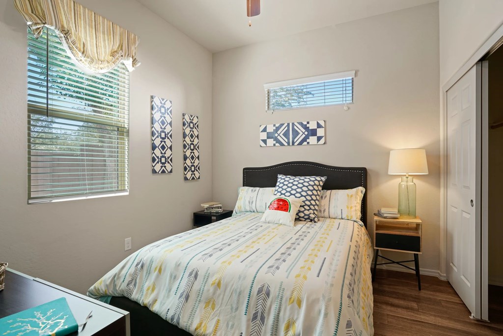 A bedroom with a bed, nightstand, and window.