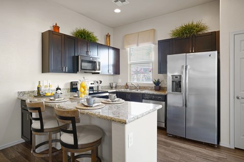 A kitchen with a table and chairs and a refrigerator.