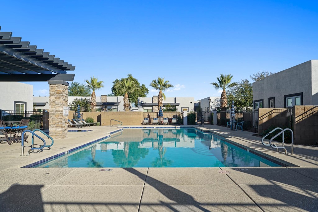 A swimming pool with a slide and palm trees in the background.