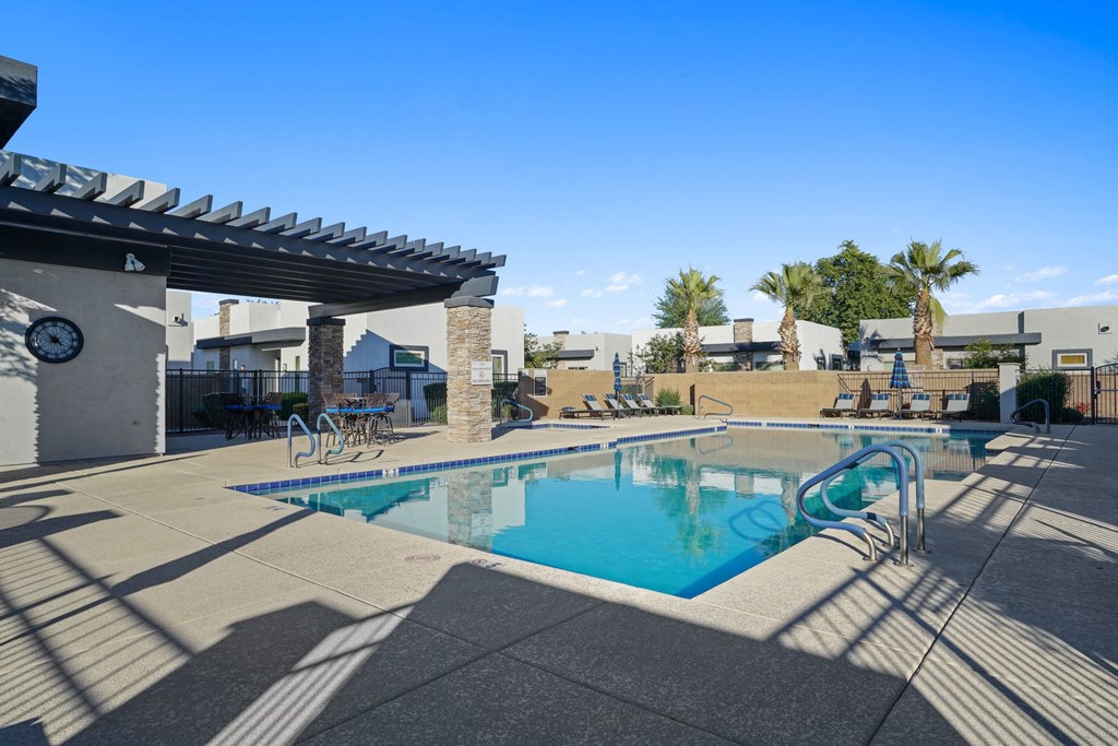 A swimming pool with a sun shade over it.