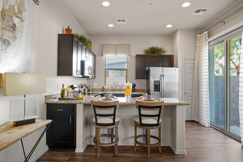 A kitchen with a black fridge and a black dishwasher.