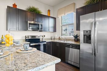 A kitchen with granite countertops and stainless steel appliances.