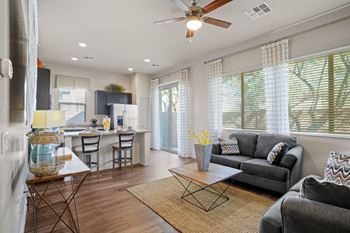 A modern living room with a grey couch and a wooden floor.