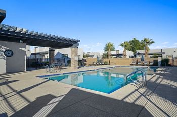 A swimming pool with a sun shade over it.