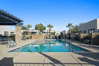 A swimming pool with a slide and palm trees in the background.