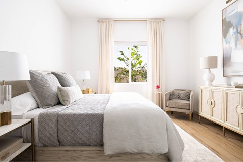 A bedroom with a large bed and a chair.