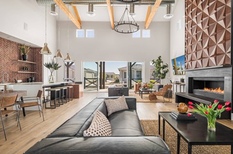 A modern living room with a black leather sofa and a fireplace.