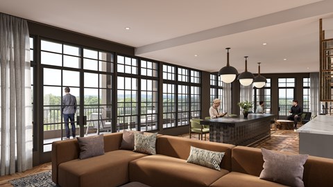 A modern living room with a large sectional sofa and a balcony with a view of the trees.