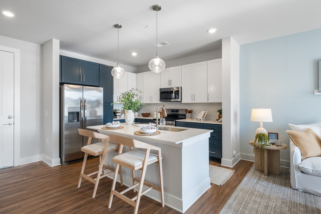 an open kitchen and living room with a large island with stools
