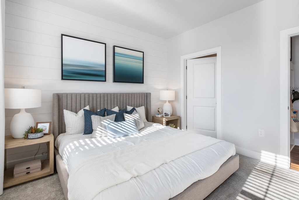 a bedroom with a large bed and two paintings on the wall