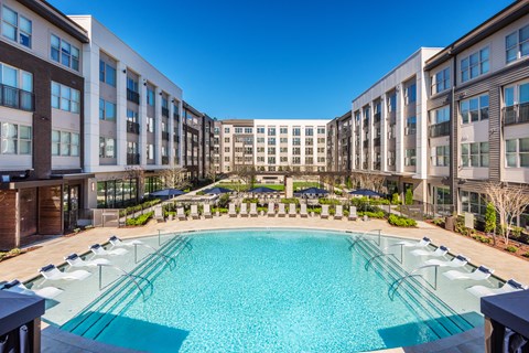 Resort-Style Pool Courtyard with Pool-Side Seating and Outdoor Dining and Grilling Areas
