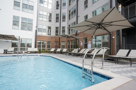 a swimming pool with chairs and umbrellas