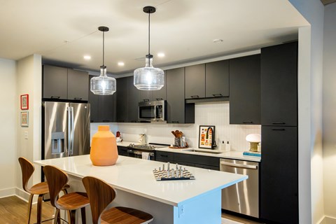 a kitchen with a white island and black cabinets