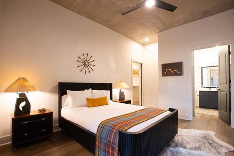 a bedroom with a large bed and a mirror in the corner