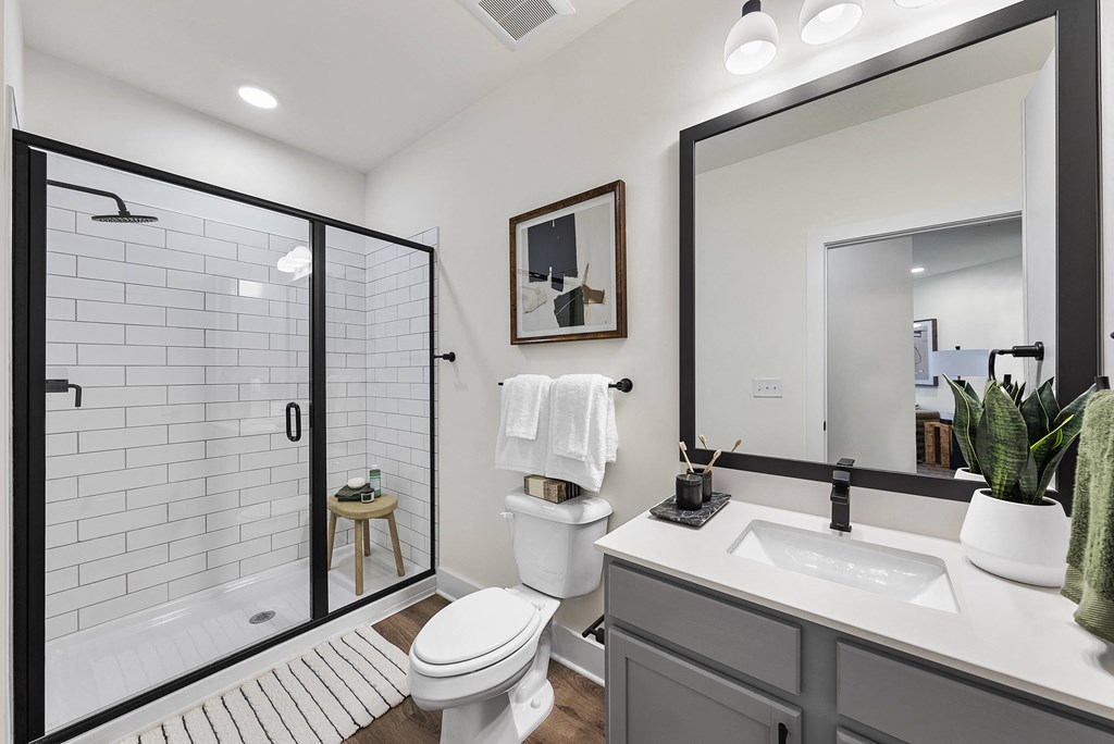 a white bathroom with a large mirror and a shower
