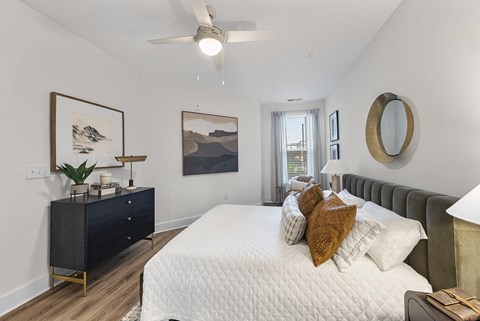a bedroom with a large white bed and a ceiling fan