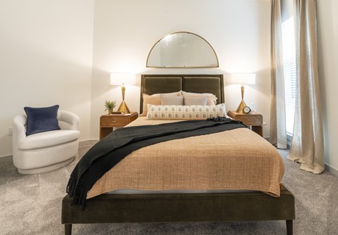 a bedroom with a bed and a chair and a window