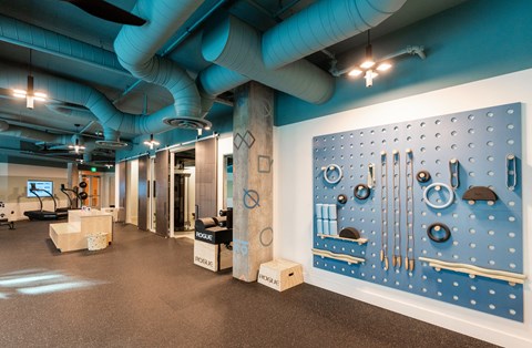 a room with a large blue wall with tools on it