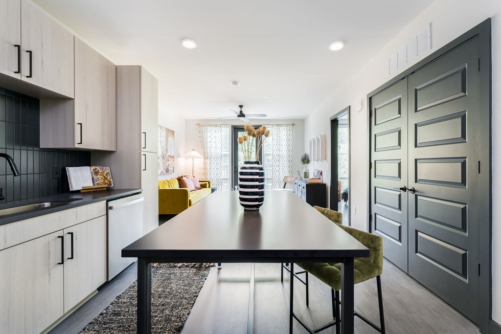 a dining area with a black dining table and yellow chairs
