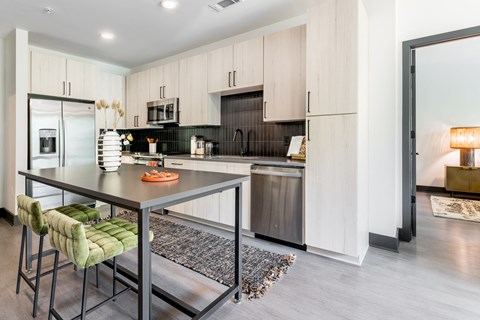 a kitchen with a large island and a table with chairs