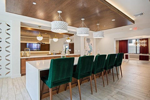 a kitchen with a bar and green chairs